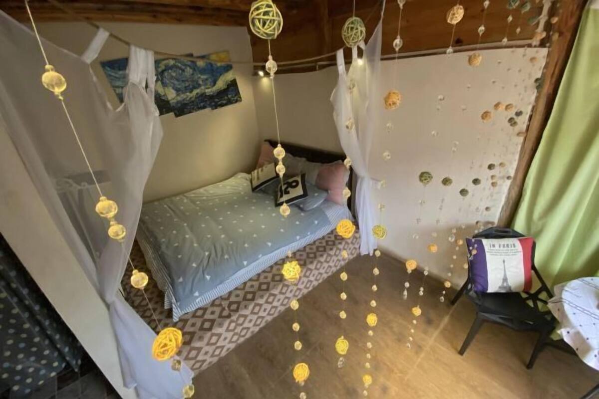 Un dormitorio con una cama, una silla y una mesa.