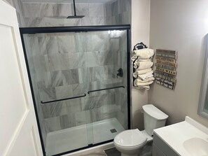 A bathroom with a glass shower enclosure, a toilet, and a sink. - Nacoochee 3, Cozy cabin, close to town, walking trails, winery, adventures  (Helen)