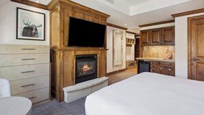 A modern kitchen with wooden cabinets, a built-in TV, and a fireplace. - The Aspen Mountain Residences 35A (Aspen)