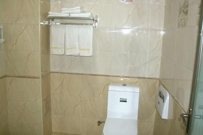 A bathroom with a toilet, a towel rack with towels, and a hand dryer. - Jinquan Business Hotel (Jinping)