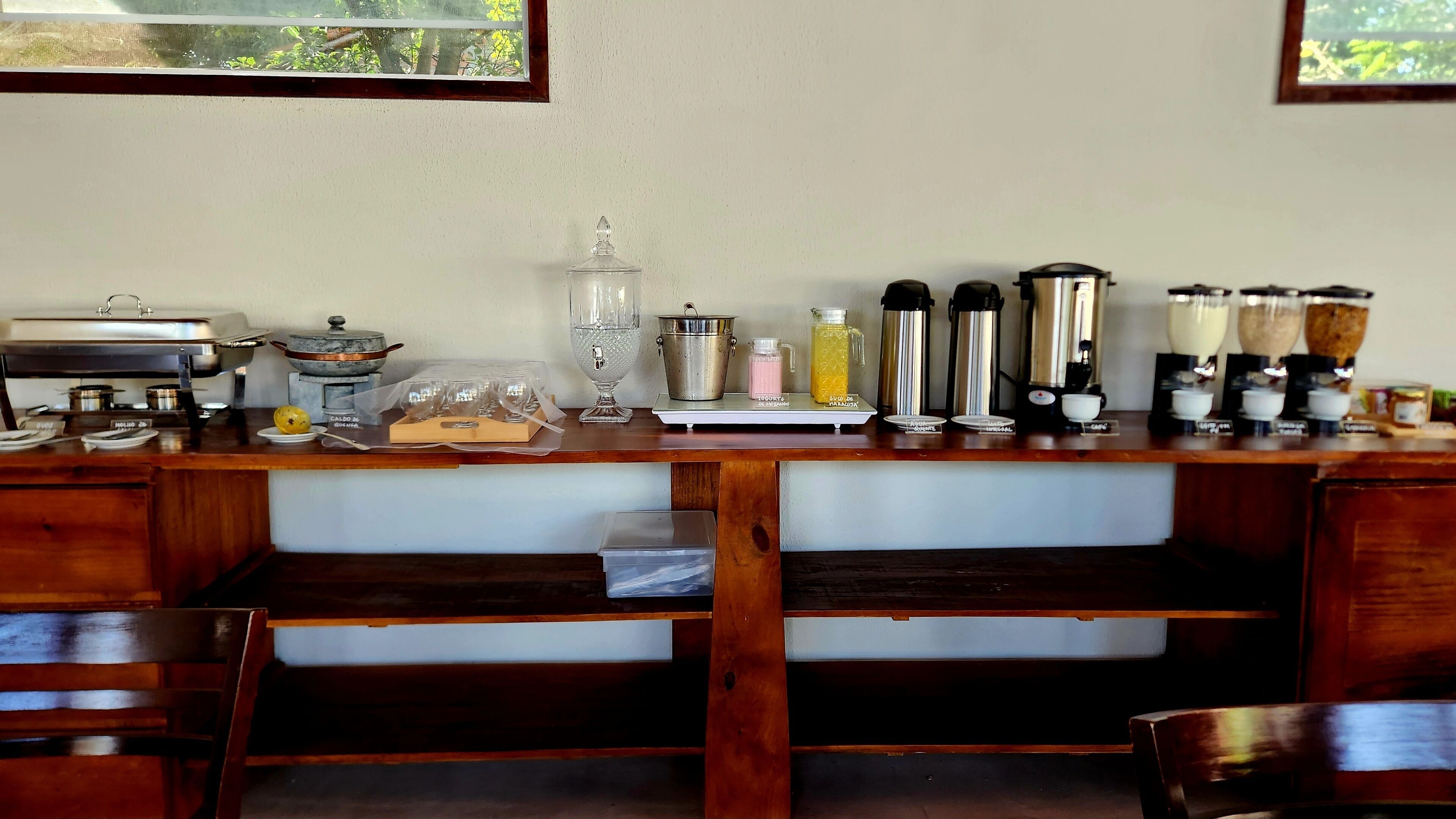 A kitchen counter with various appliances and containers, including a coffee maker, a blender, and a kettle.