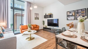 A modern living room with a sofa, coffee table, and dining area set up for a meal.