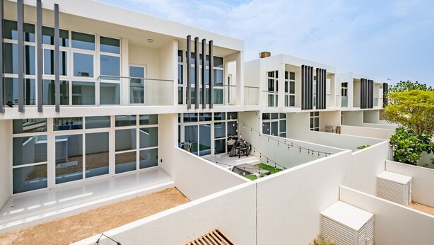 A modern multi-story building with large windows, a flat roof, and a minimalist design.