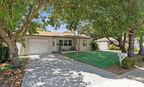 Set amidst mature trees, this charming home features a garage, front porch, and well-manicured lawn.