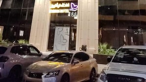 Un hotel con fachada moderna, varios pisos y una entrada destacada con un letrero de neón.
