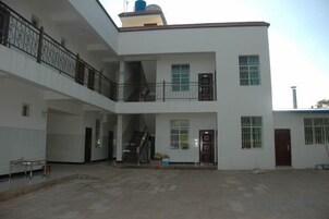 Un edificio de varios niveles con balcones, escaleras y puertas.
