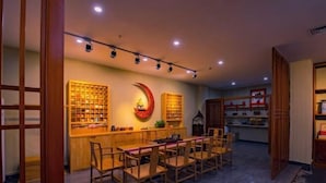 A restaurant with wooden furniture and shelves of books. - Tongjing Hotel (Renhua)