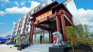 A hotel with traditional architectural elements, including a red wooden entrance and lion statues. - Tongjing Hotel (Renhua)