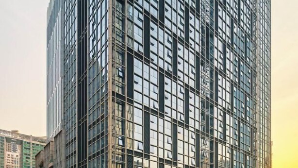 Un edificio alto y moderno con una fachada de ventanas enrejadas.