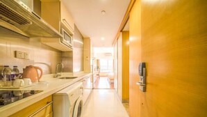 Una cocina moderna con lavadora, un lavamanos y una encimera con diversos objetos.