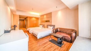 Una habitación de hotel con cama, sofá, escritorio y espejo.