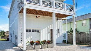 En hvid bygning med carport og balkon.