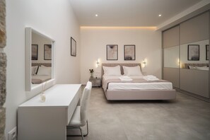Ein modernes Schlafzimmer mit einem großen Bett, einem Nachttisch, einem Spiegel und Kunstwerken an den Wänden.
