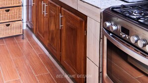 Une cuisine avec des meubles de rangement en bois, un évier en acier inoxydable, un four à micro-ondes et une cuisinière.