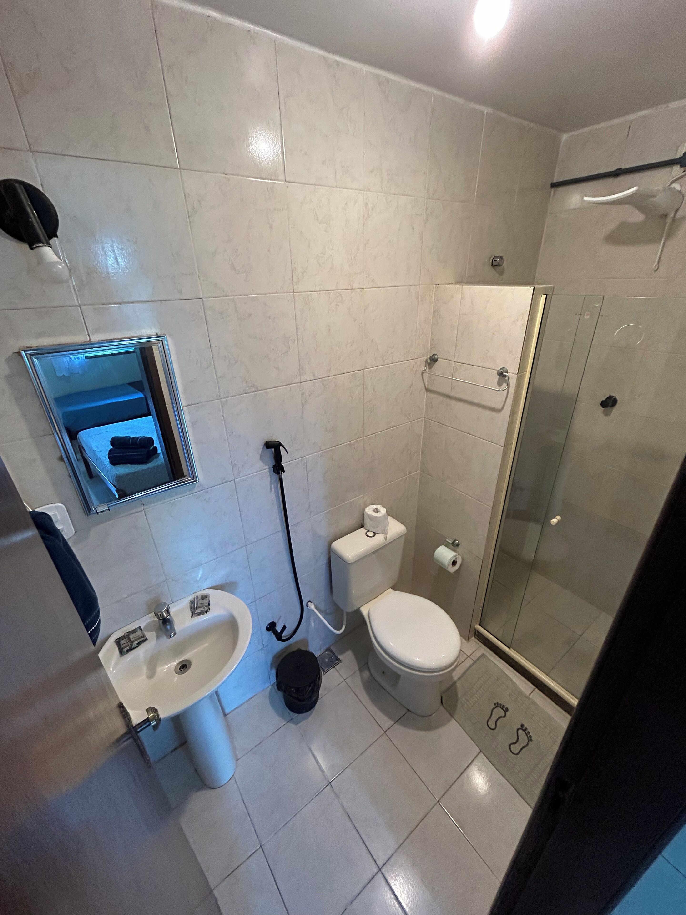 A bathroom with a sink, toilet, and glass-enclosed shower.