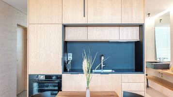 Eine moderne Küche mit Holzausstattung, Backofen und schwarzer Arbeitsplatte.