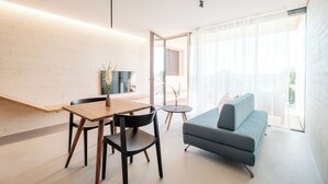 Una sala de estar moderna con un sofá, una mesa de comedor con sillas y una pequeña mesita auxiliar.