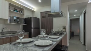 A modern kitchen with granite countertops, a microwave, a refrigerator, and a gas stove. - Modern Apartment with Terrace and Pool  (Tlajomulco de Zúñiga)
