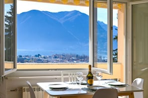 Una mesa de comedor con una botella de vino y copas, con vistas a la montaña.