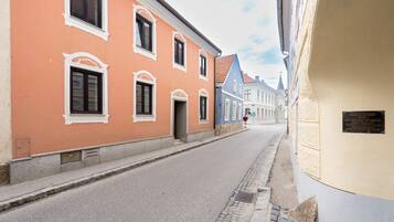 Eine enge Straße gesäumt von historischen Gebäuden, darunter ein Gebäude mit einer Gedenktafel.