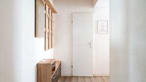 Un couloir avec une armoire en bois, une porte et une citation encadrée accrochée au mur.