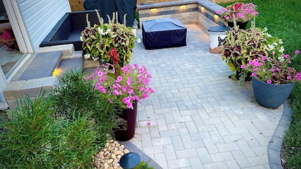 A patio with a stone pathway, potted plants, a barbecue grill, and a covered seating area. - Blueberry Bungalow with Stunning Patio & Garden (Dayton)