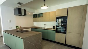 A modern kitchen with a central island, built-in appliances, and a sleek design.