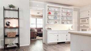 A modern kitchen with white cabinetry, a built-in microwave, and a countertop. - The Cozy Home near Lancium, ACU, HSU, Hendrick (Abilene)