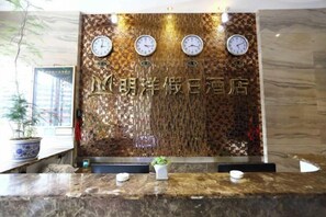 Una recepción con un llamativo muro decorado con relojes y un letrero con caracteres chinos.