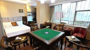 A hotel room with a bed, a pool table, a desk, and a chair.