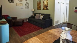 A living room with a sofa, a coffee table, and a red rug. - Warm & Cozy Home Near SeaWorld/Fiesta TX/Lackland AFB (San Antonio)