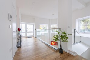 Enjoy a warm and inviting space with a fireplace, balcony views, and a touch of greenery.