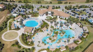 An aerial view of a resort with multiple swimming pools, landscaped areas, and a large parking lot. - House near Disney world and many other attractions and theme parks. (Davenport)