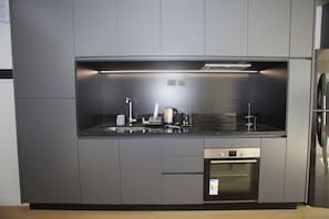 Una cocina moderna con horno empotrado, lavavajillas y electrodomésticos de acero inoxidable.