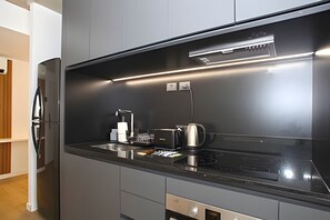 A modern kitchen with a black countertop, stainless steel appliances, and a built-in oven. - Urban Rent - Tu hogar temporario (Buenos Aires)