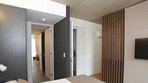 Un dormitorio moderno con cama, armario y puerta que da a otra habitación.