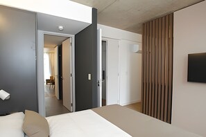 Un dormitorio moderno con cama, armario y puerta que da a otra habitación.