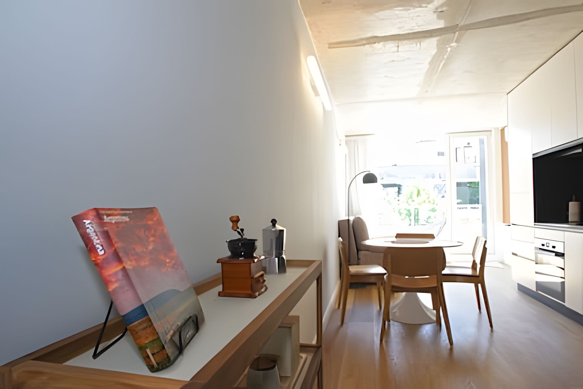 Eine moderne Küche mit Essbereich, Holzmöbeln und einem großen Fenster.