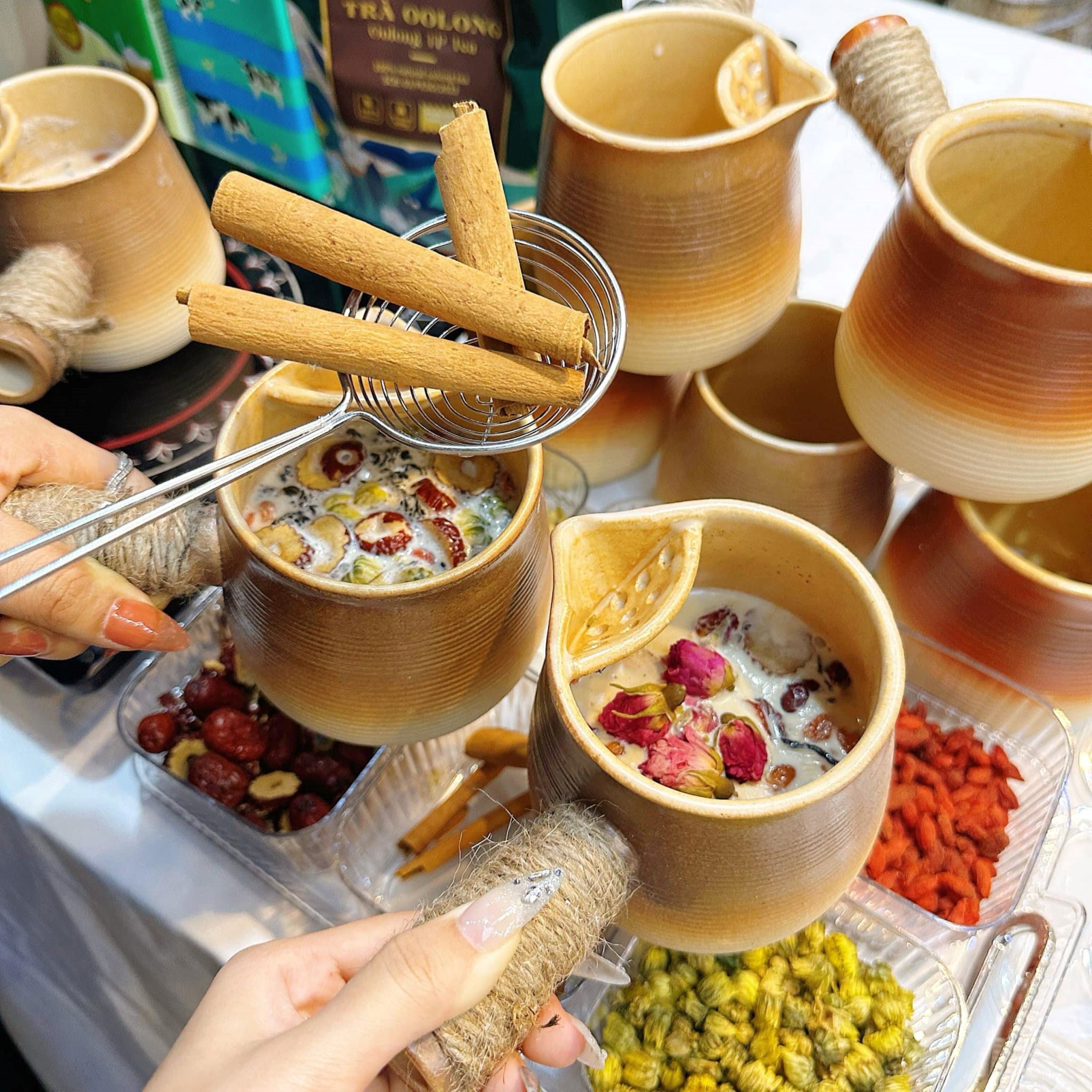 A variety of bowls with different contents, including fruits and nuts, held by hands.