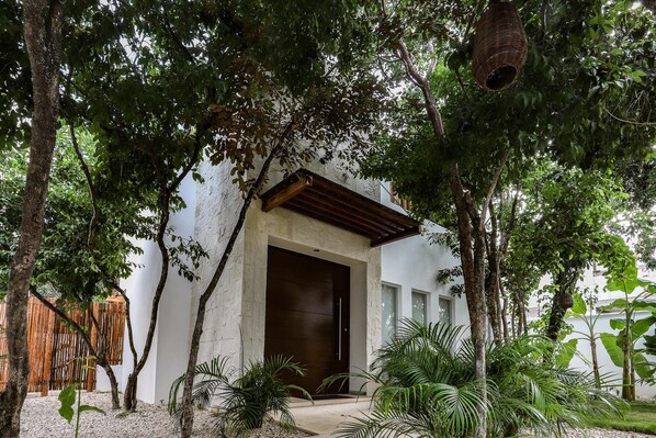 Un edificio con un'ampia porta in legno e un portico coperto.