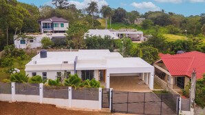 A residential area with modern houses, a gated entrance, and lush greenery.