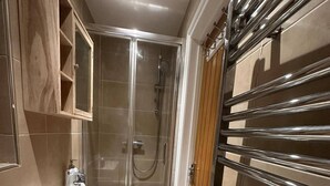 A modern bathroom with a glass-enclosed shower, a white sink, and a wooden cabinet.