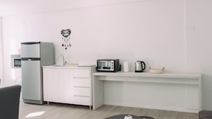 A modern kitchen with a refrigerator, microwave, toaster, and kettle on a white countertop. - Maison Work & Travel 1 - Palermo (Buenos Aires)