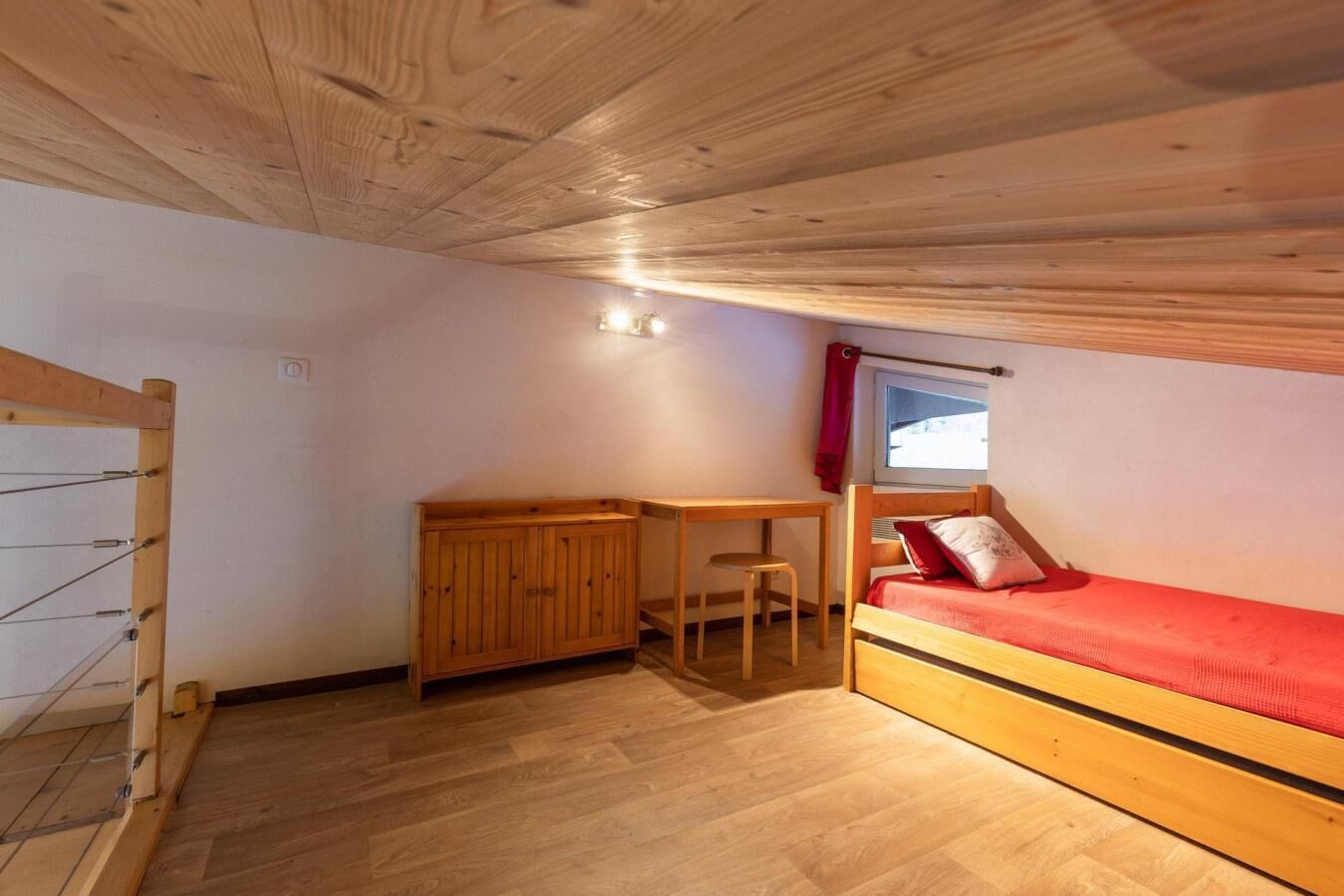 A compact room with a bunk bed, a desk, and a chair.