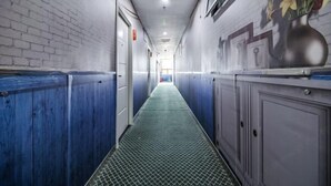 A hallway with a patterned floor, blue walls, and a door at the end.