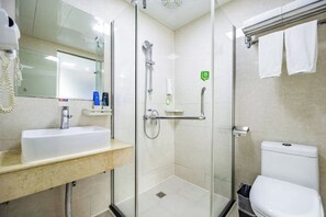 Une salle de bain moderne avec une douche à parois de verre, un lavabo doté d’un plan de toilette en marbre et des toilettes.