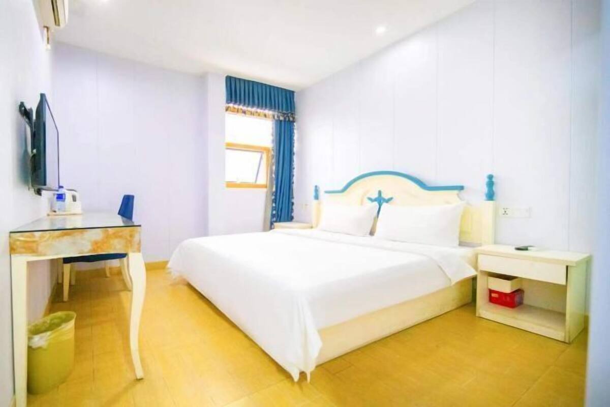 Une chambre à coucher comprenant un lit, une table de chevet, une commode et un bureau avec une chaise.