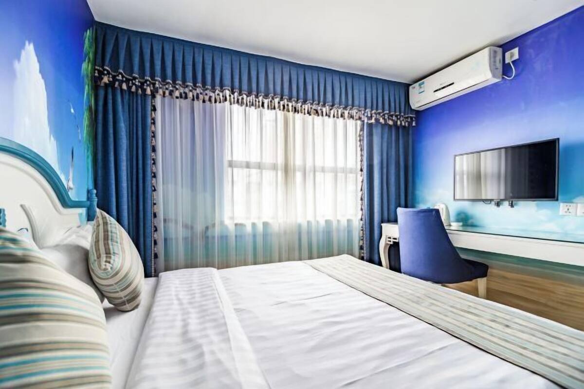 Une chambre d’hôtel équipée d’un lit, d’un bureau, d’une chaise, d’une télévision et d’un appareil de climatisation.