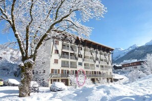 A multi-story building with balconies, surrounded by snow-covered trees and mountains in the background. - 70m from ski slopes, Ground floor, balcony, tv, 43m², La Clusaz (La Clusaz)