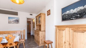A wooden dining area with a table and chairs, a small stool, and a cabinet with the word 'Personnel' on it.